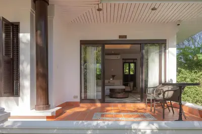 a house with a patio with a table and chairs at The Pe La Resort, Phuket - SHA Extra Plus in Kamala Beach
