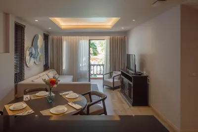 a living room with a couch and a table with chairs at The Pe La Resort, Phuket - SHA Extra Plus in Kamala Beach