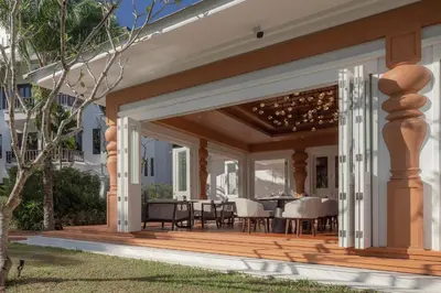 a wooden deck with a dining area on a house at The Pe La Resort, Phuket - SHA Extra Plus in Kamala Beach