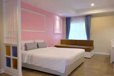 a bedroom with a large bed and a couch at The Beach Boutique House in Kata Beach