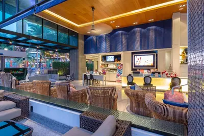 a restaurant with chairs and a bar with a tv at The Beach Boutique House in Kata Beach