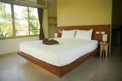 a large white bed in a room with a large window at Cocco House in Ao Nang Beach