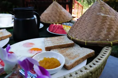 a plate of food with toast and fruit on a table at Cocco House in Ao Nang Beach