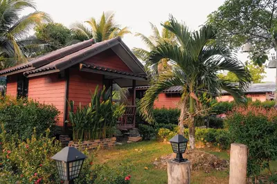 a red house with a palm tree in front of it at Cocco House in Ao Nang Beach