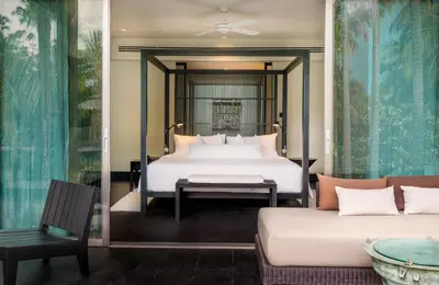 a bedroom with a bed and a couch at Twinpalms Surin Beach Phuket in Surin Beach