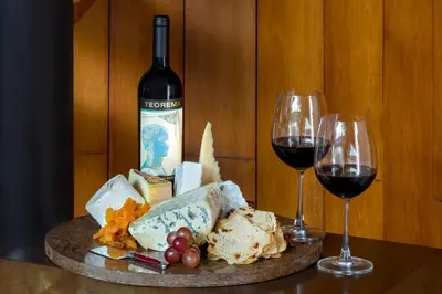 a table with two glasses of wine and cheese at Twinpalms Surin Beach Phuket in Surin Beach