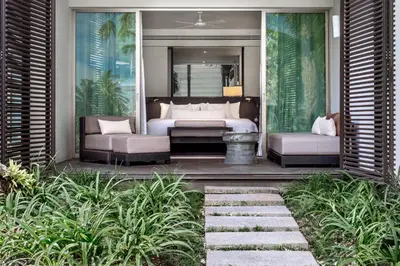 a bedroom with a bed and two couches at Twinpalms Surin Beach Phuket in Surin Beach