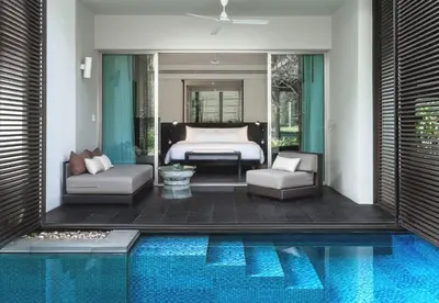 a bedroom with a bed and a swimming pool at Twinpalms Surin Beach Phuket in Surin Beach
