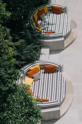 a row of benches with pillows and trees at The Royal Paradise Hotel & Spa in Patong Beach
