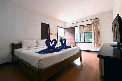 two swans are sitting on a bed in a room at Phi Phi Twin Palms Bungalow in Phi Phi Don