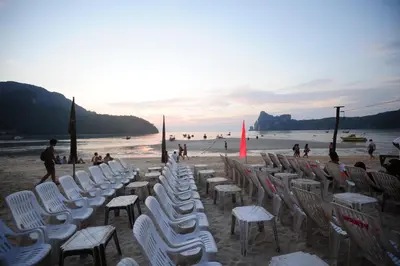 a group of chairs and tables on a beach at Phi Phi Twin Palms Bungalow in Phi Phi Don