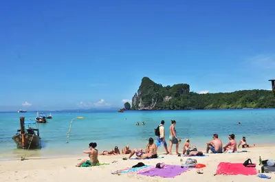 a group of people sitting on a beach at Phi Phi Twin Palms Bungalow in Phi Phi Don