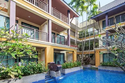 an apartment building with a swimming pool in front of it at Diamond Cottage Resort & Spa in Karon Beach