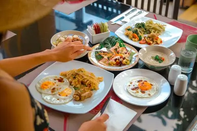 a table with plates of food on a table at Diamond Cottage Resort & Spa in Karon Beach