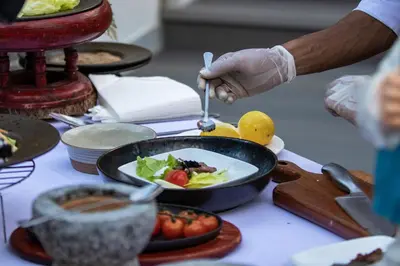 a person in gloves preparing food on a table at Diamond Cottage Resort & Spa in Karon Beach
