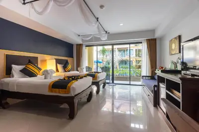 a hotel room with two beds and a television at Diamond Cottage Resort & Spa in Karon Beach