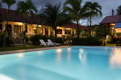 a large blue swimming pool in front of a house at The Golddiggers Resort in Nai Yang Beach