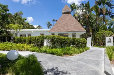 a driveway leading to a white house with a tower at Centara Karon Resort Phuket in Karon Beach