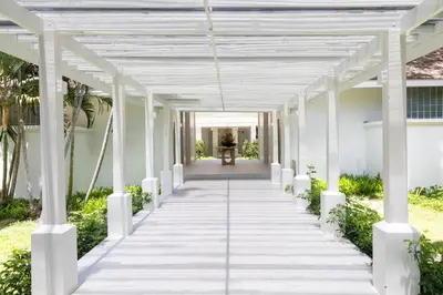 a white walkway leading to the front of a house at Centara Karon Resort Phuket in Karon Beach