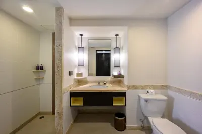 a bathroom with a sink and a toilet and a mirror at Centara Kata Resort Phuket in Kata Beach