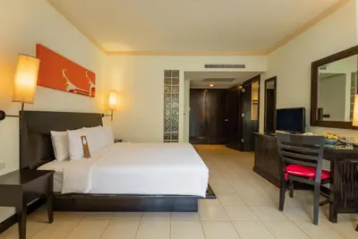 a hotel room with a bed and a desk at Centara Kata Resort Phuket in Kata Beach