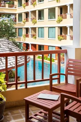 a balcony with two chairs and a swimming pool at Patong Paragon Resort & Spa SHA Extra Plus in Patong Beach