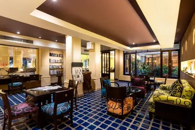 a lobby of a hotel with tables and chairs at Patong Paragon Resort & Spa SHA Extra Plus in Patong Beach