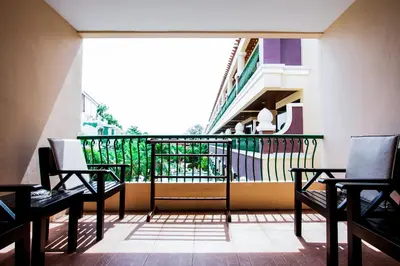 a balcony with chairs and a railing with a staircase at Karon Sea Sands Resort-SHA PLUS in Karon Beach