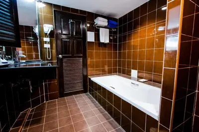 a bathroom with a large tub and a sink at Karon Sea Sands Resort-SHA PLUS in Karon Beach