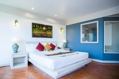 a bedroom with a large white bed and blue walls at Karon Sea Sands Resort-SHA PLUS in Karon Beach