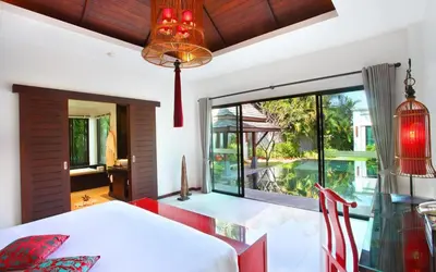 a bedroom with a bed and a large window at The Bell Pool Villa Resort Phuket in Kamala Beach