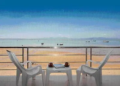 a table and chairs on a balcony overlooking the beach at Koh Kwang Seaview in Klong Muang Beach