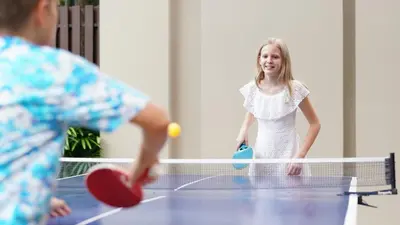 a boy and a girl playing a game of tennis at Holiday Inn Resort Phuket Surin Beach by IHG in Surin Beach