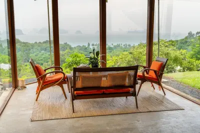 a dining room with a table and chairs in front of windows at Koyao Island Resort in Ko Yao Noi