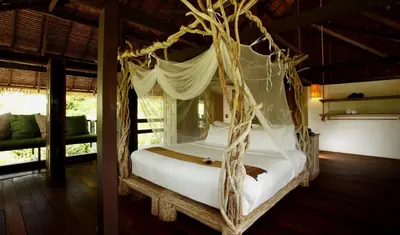 a bedroom with a canopy bed in a room at Koyao Island Resort in Ko Yao Noi