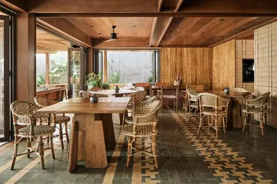 a dining room with wooden tables and chairs at Barcelo Coconut Island, Phuket in Phuket Town