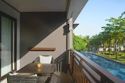 a balcony with a table and chairs and a pool at Phuket Marriott Resort and Spa, Nai Yang Beach in Nai Yang Beach