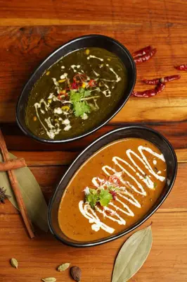 two black bowls of soup on a wooden table at JW Marriott Phuket Resort and Spa in Mai Khao Beach