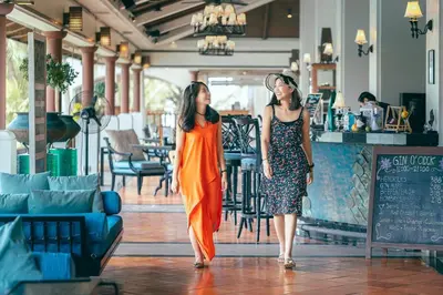 two women walking through a restaurant with at JW Marriott Phuket Resort and Spa in Mai Khao Beach