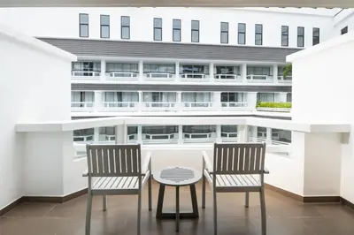 two chairs and a table in front of a building at Radisson RED Phuket Patong Beach in Patong Beach
