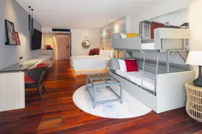 a room with bunk beds and a living room at Radisson RED Phuket Patong Beach in Patong Beach