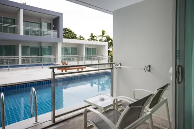 a balcony with chairs and a swimming pool at Sugar Palm Grand Hillside - SHA Plus in Kata Beach