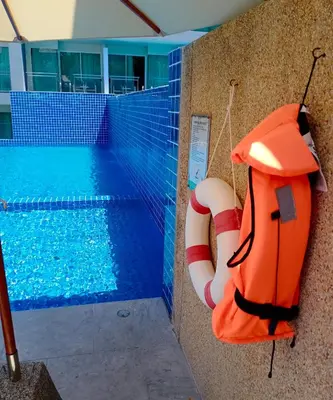 a swimming pool with a life preserver next to a swimming pool at Sugar Palm Grand Hillside - SHA Plus in Kata Beach