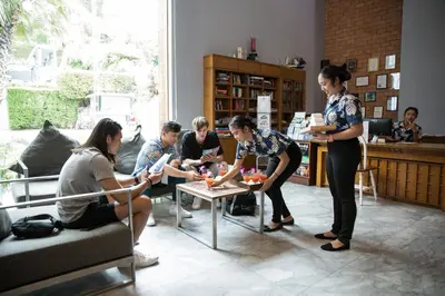 a group of people sitting around a table in a room at Sugar Palm Grand Hillside - SHA Plus in Kata Beach