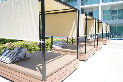 a row of beds on a balcony of a building at Sugar Palm Grand Hillside - SHA Plus in Kata Beach