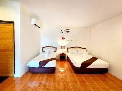 a room with two beds and a painting of a woman at Mild Garden View Resort in Ao Nang Beach