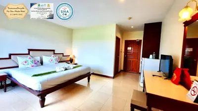 a bedroom with a large bed and a refrigerator at Mei Zhou Phuket Hotel - SHA Plus in Phuket Town
