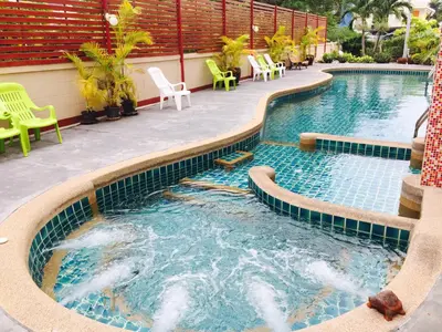 a swimming pool with chairs and chairs in a resort at Mei Zhou Phuket Hotel - SHA Plus in Phuket Town