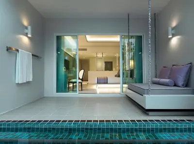 a room with a pool with a couch and a bedroom at Chanalai Romantica Resort - Adults Only, Kata Beach in Kata Beach