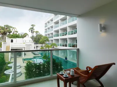 an apartment balcony with a view of a swimming pool at Chanalai Romantica Resort - Adults Only, Kata Beach in Kata Beach